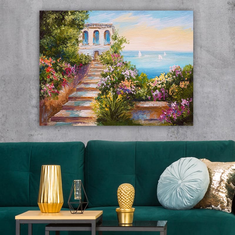Lerretsbilde 70x100 cm - Vakker trapp omgitt av fargerike blomster som fører ned til havet og en bygning med blå vinduer - Grønn / Rosa / Blå - Interiør - Maleri & posters - Lerretsbilder