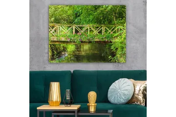 Lerretsbilde 70x100 cm - Vakker trebro omgitt av grøntområder og blomster ved en rolig vannflate - Grønn / Rosa / Brun - Interiør - Maleri & posters - Lerretsbilder