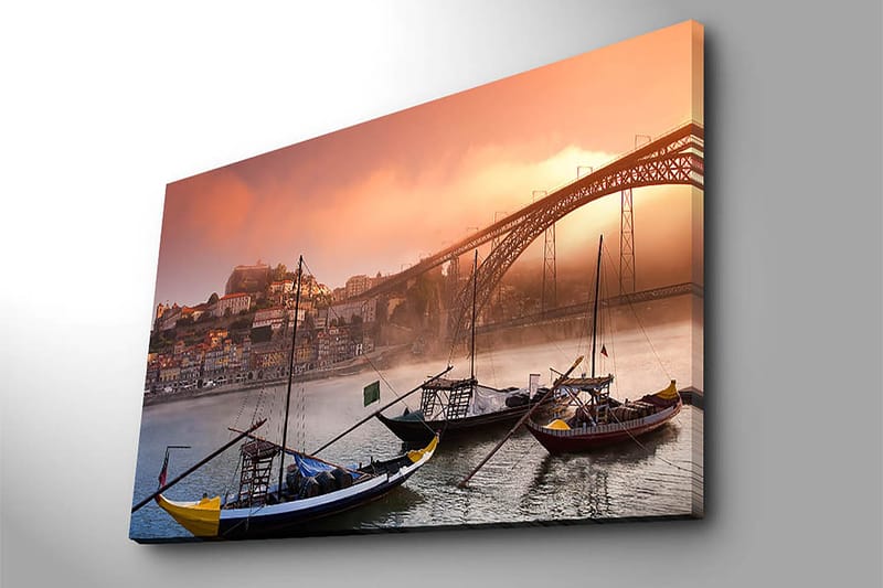 Lerretsbilde 70x100 cm - Vakker utsikt over elven med tradisjonelle båter og en majestetisk bro i bakgrunnen, omgitt av fargerike hus - Oransje / Blå / Gul - Interiør - Maleri & posters - Lerretsbilder