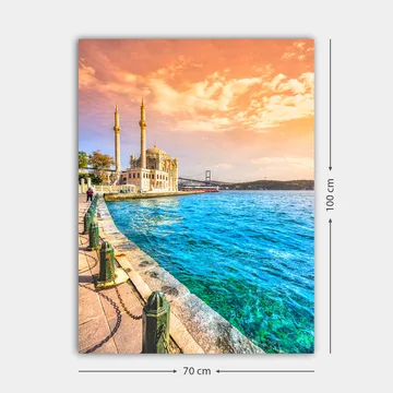Lerretsbilde 70x100 cm - Vakker utsikt over en moské ved vannet med en bro i bakgrunnen under en fargerik himmel - Blå / Oransje / Beige - Interiør - Maleri & posters - Lerretsbilder