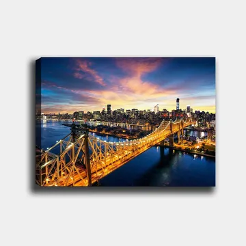 Lerretsbilde 70x100 cm - Vakker utsikt over Queensboro Bridge med en bysilhuett i bakgrunnen under en fargerik solnedgang - Blå / Oransje / Gul - Interiør - Maleri & posters - Lerretsbilder