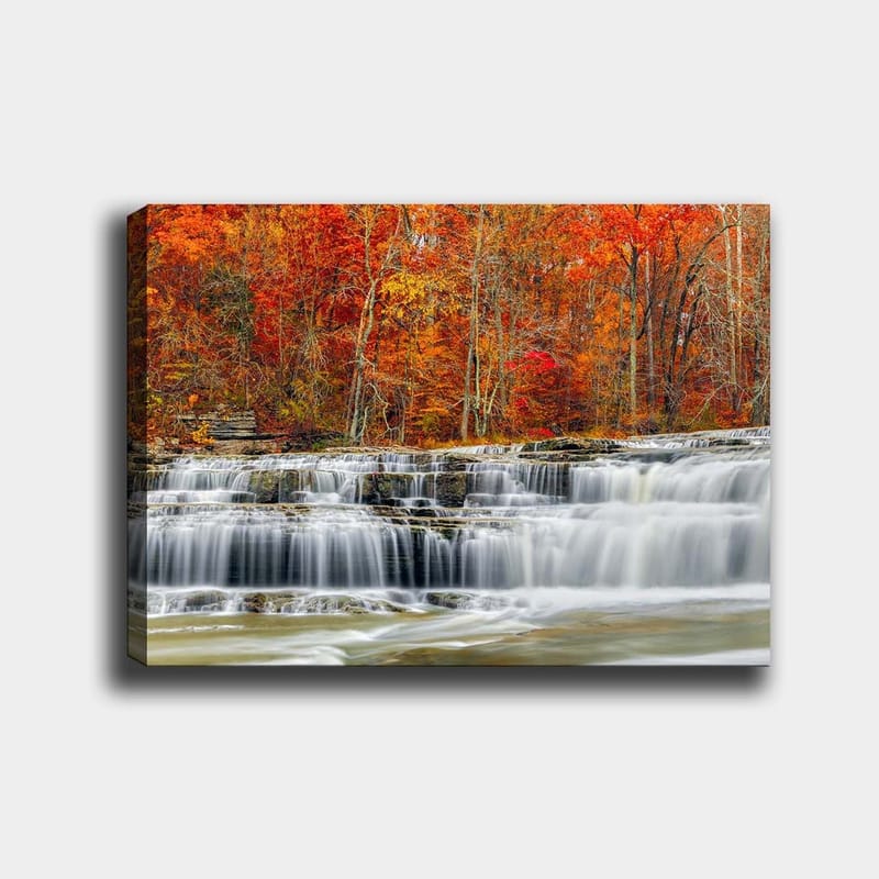 Lerretsbilde 70x100 cm - Vakkert fossefall omgitt av høstfarger i røde og oransje nyanser, Rød / Oransje / Grå