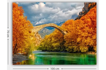 Lerretsbilde 70x100 cm - Vakkert høstlandskap med en gammel steinbro som strekker seg over en glitrende elv omgitt av fargerike trær - Oransje / Grønn / Blå - Interiør - Maleri & posters - Lerretsbilder