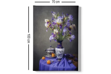 Lerretsbilde 70x100 cm - Vakkert stilleben med en vase fylt med lilla irisblomster og en skål med appelsiner - Lilla / Hvit / Oransje - Interiør - Maleri & posters - Lerretsbilder