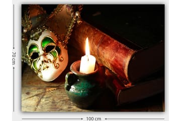 Lerretsbilde 70x100 cm - Venetiansk maske i fokus med et brennende stearinlys og gamle bøker i bakgrunnen - Grønn / Brun / Hvit - Interiør - Maleri & posters - Lerretsbilder