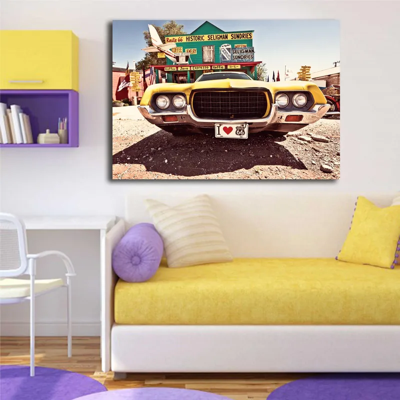 Lerretsbilde 70x100 cm - Veteranbil i gult foran et nostalgisk veiskilt langs Route 66 - Gul / Svart / Sølv - Interiør - Maleri & posters - Lerretsbilder