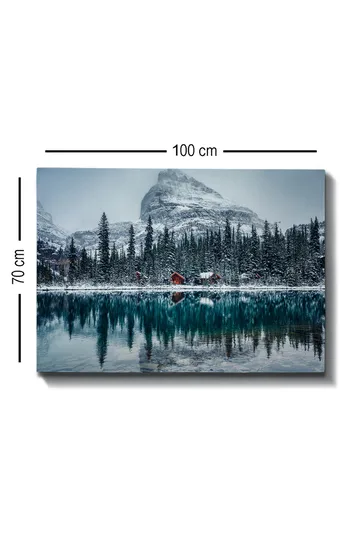 Lerretsbilde 70x100 cm - Vinterlandskap med snødekte fjell og en speilblank innsjø omgitt av grantrær og røde hytter - Mørk grønn / Blå / Hvit - Interiør - Maleri & posters - Lerretsbilder