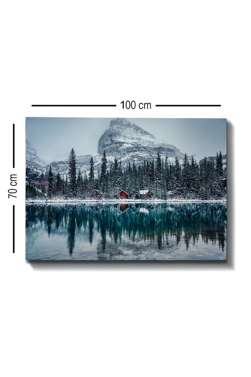 Lerretsbilde 70x100 cm - Vinterlandskap med snødekte fjell og en speilblank innsjø omgitt av grantrær og røde hytter - Mørk grønn / Blå / Hvit - Interiør - Maleri & posters - Lerretsbilder