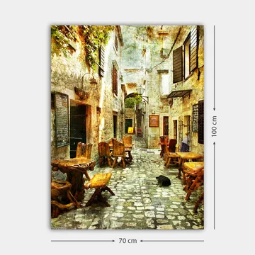 Lerretsbilde 70x100 cm - Pittoresk smug med trebord og stoler, omgitt av gamle steinhus - Brun / Grå / Grønn - Interiør - Maleri & posters - Lerretsbilder