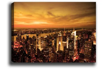 Lerretsbilde 70x100 cm - Panoramautsikt over en by ved solnedgang med høye bygninger og en dramatisk himmel - Oransje / Gull / Svart - Interiør - Maleri & posters - Lerretsbilder