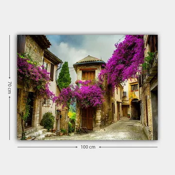 Lerretsbilde 70x100 cm - Pittoresk smug omgitt av fargerike blomster i sjarmerende landsbymiljø - Lilla / Grønn / Beige - Interiør - Maleri & posters - Lerretsbilder