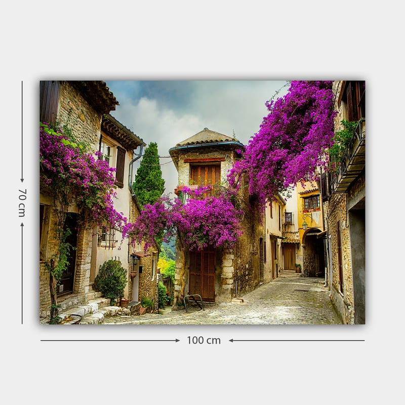 Lerretsbilde 70x100 cm - Pittoresk smug omgitt av fargerike blomster i sjarmerende landsbymiljø - Lilla / Grønn / Beige - Interiør - Maleri & posters - Lerretsbilder