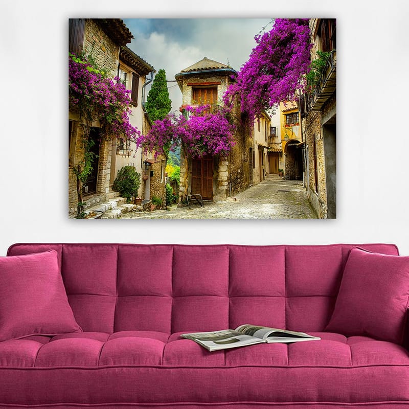 Lerretsbilde 70x100 cm - Pittoresk smug omgitt av fargerike blomster i sjarmerende landsbymiljø - Lilla / Grønn / Beige - Interiør - Maleri & posters - Lerretsbilder