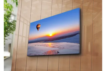 Lerretsbilde 70x45 cm - Fargerik varmluftsballong som svever over en soloppgang i horisonten - Blå / Oransje / Gul - Interiør - Maleri & posters - Lerretsbilder