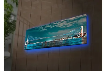 Lerretsbilde med LED-belysning 30x90 cm - Bro over et rolig vann med bylys i bakgrunnen - Mørk blå / Turkis / Lys grønn - Interiør - Maleri & posters - Lerretsbilder