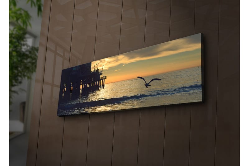 Lerretsbilde med LED-belysning 30x90 cm - Solnedgang over havet med en fugl i flukt, Oransje / Blå / Grå