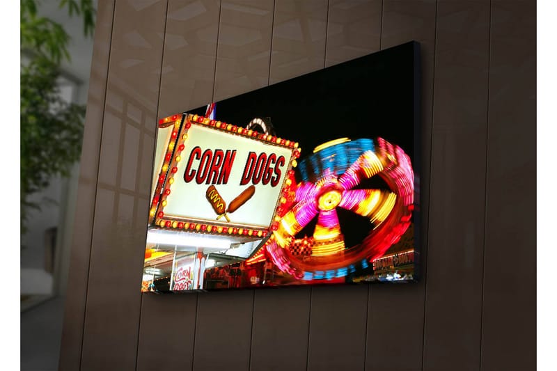Lerretsbilde med LED-belysning 45x70 cm - Lyst og fargerikt skilt med teksten CORN DOGS og en snurrende karusell i bakgrunnen, Rød / Gul / Blå