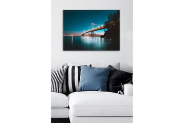 Lerretsbilde - Opplyst bro over en stille vannflate med byens skyline i bakgrunnen - Blå / Oransje / Svart - Interiør - Maleri & posters - Lerretsbilder