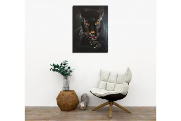 Lerretsbilde - Svart panter med intense øyne som slikker poten sin - Svart / Gull / Mørkegrønn - Interiør - Maleri & posters - Lerretsbilder